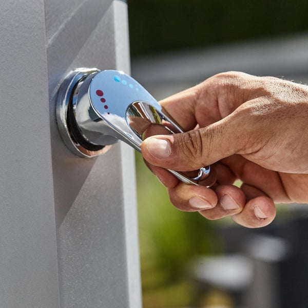 Hand betätigt Wasserhahn einer Gartendusche