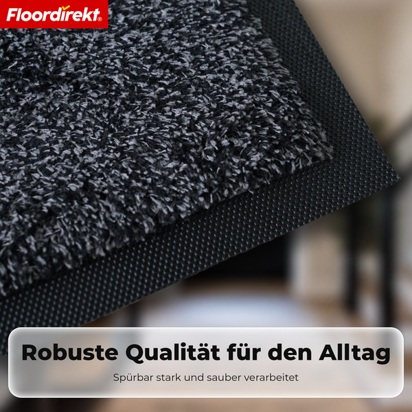 Floordirekt Logo. Detailaufnahme einer Schmutzfangmatte mit meliertem Flor, robustem Gummirand und hoher Verarbeitungsqualität.