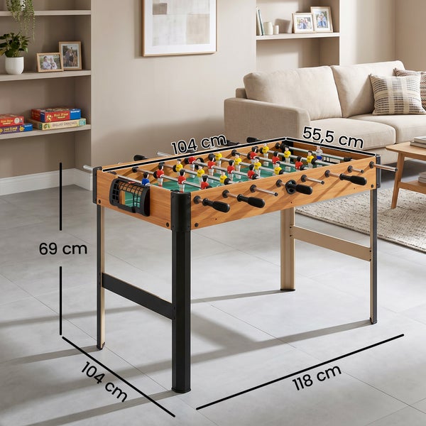 Tischkicker in Holzoptik im Wohnzimmer mit Abmessungen 118 mal 104 mal 69 Zentimeter und Spielfläche 104 mal 55,5 Zentimeter.