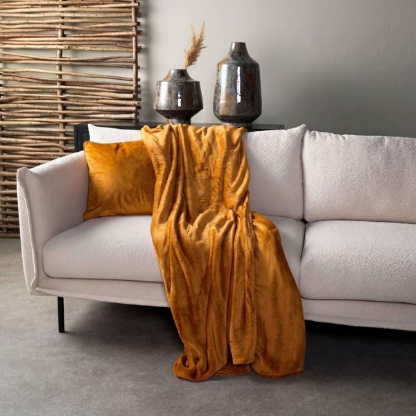 Dekoratives Wohnzimmer mit Sofa, Kissen und Kuscheldecke