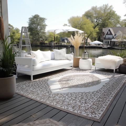 Terrassenszene mit Sofa, Teppich und Blick auf den See