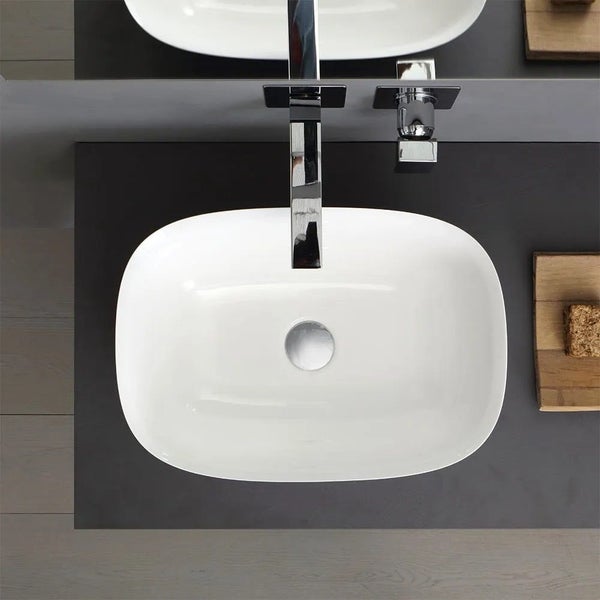 Aufsicht auf ein rechteckiges Waschbecken aus Keramik mit abgerundeten Ecken und einer Armatur.