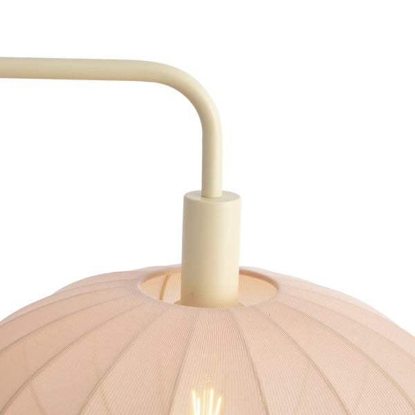 Detailansicht einer Lampe mit gebogenem Metallarm und plissiertem Stoffschirm in Beige und Rosa.