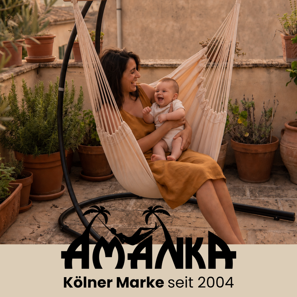 Frau mit Baby in einer Hängematte mit Gestell auf einer Terrasse mit zahlreichen Pflanzen und Amanka Logo.