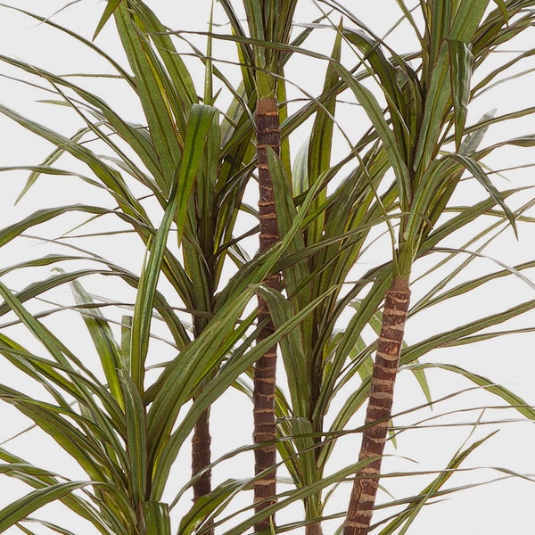 Grünes Blatt und hellrosa Blütenblätter einer künstlichen Blume aus Textil.
