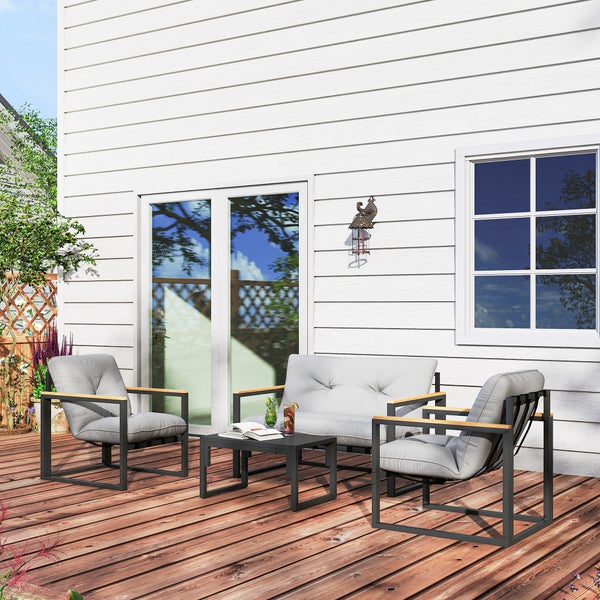 Moderne Garten-Lounge-Sitzgruppe aus Metall und Holz mit zwei Sesseln, einem Sofa und einem Tisch auf einer Holzterrasse vor einer Hauswand.