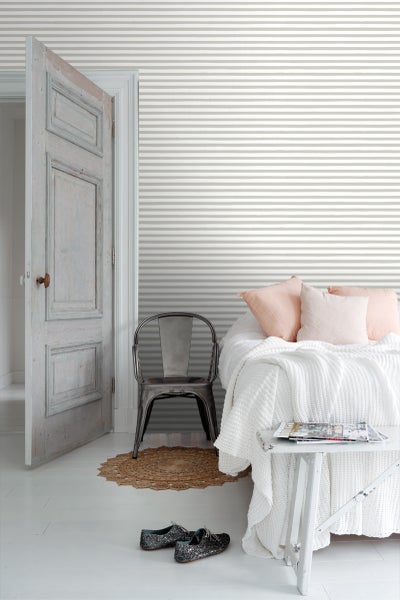 Schlafzimmer mit gestreifter Tapete, Bett, Stuhl und offen stehender Tür