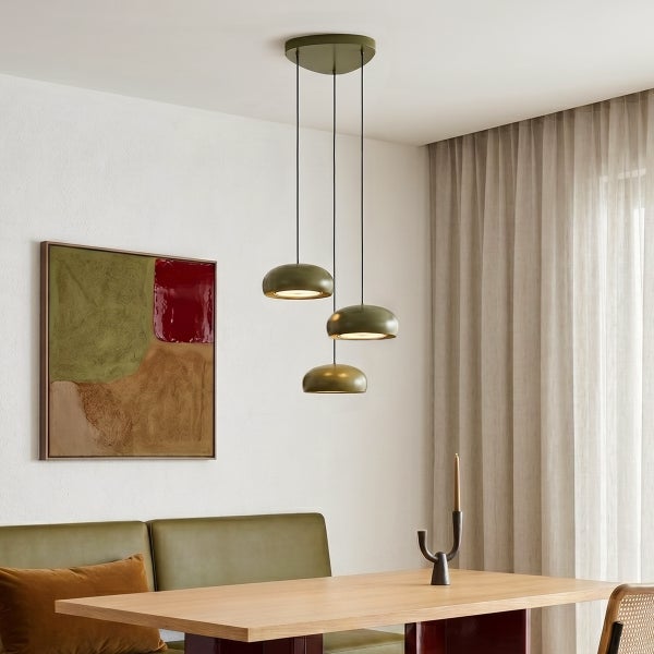 Moderne dreiflammige Pendelleuchte mit halbkugelförmigen Schirmen über einem Holzesstisch in einem modernen Esszimmer.