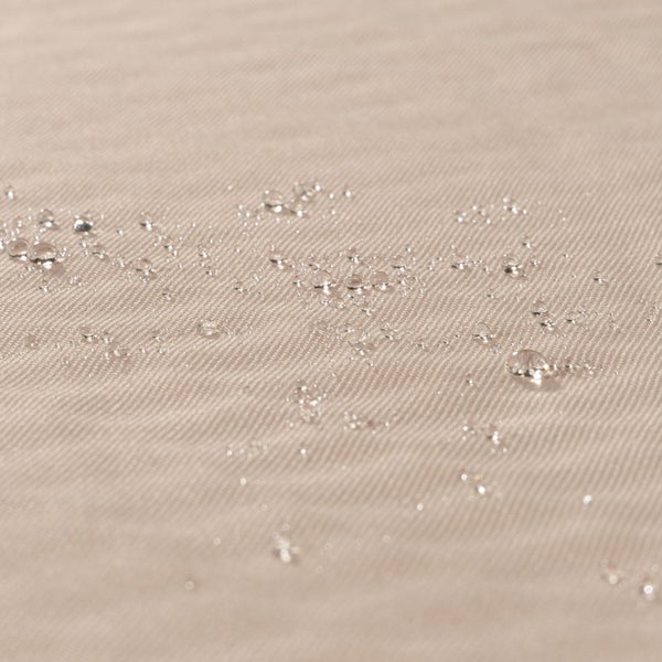 Nahaufnahme von wasserabweisendem Stoff mit Wassertropfen, die auf der gewebten Oberfläche abperlen.