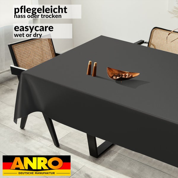 Pflegeleichte, abwischbare Tischdecke in Dunkelgrau auf einem Esstisch mit Stühlen und Dekoration. ANRO Logo.