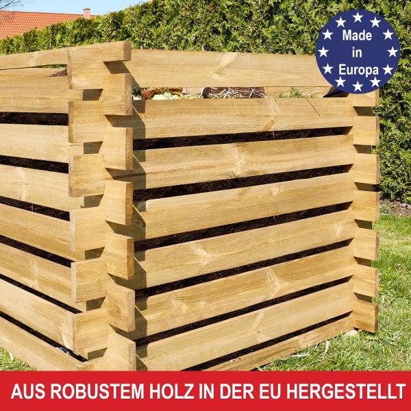 Quadratischer Komposter aus Holzlatten in einem blühenden Garten mit einem Spaten, einem Korb mit Bioabfall und einer Gießkanne.