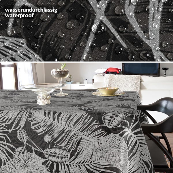 Wasserundurchlässige Tischdecke mit Blattmuster in einem hellen Wohnzimmer, Nahaufnahme von Wassertropfen auf der wasserabweisenden Oberfläche.