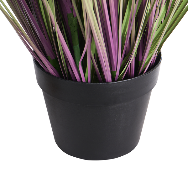 Künstliche Graspflanze mit violetten und grünen Halmen in einem schwarzen Kunststofftopf.