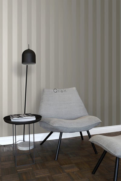 Innenraum mit gestreifter Tapete, Sessel, Hocker und Stehleuchte