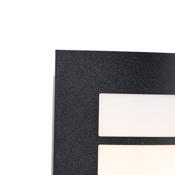 Detail einer schwarzen Außenwandleuchte mit strukturierter Oberfläche und rechteckigen weißen Diffusoren.