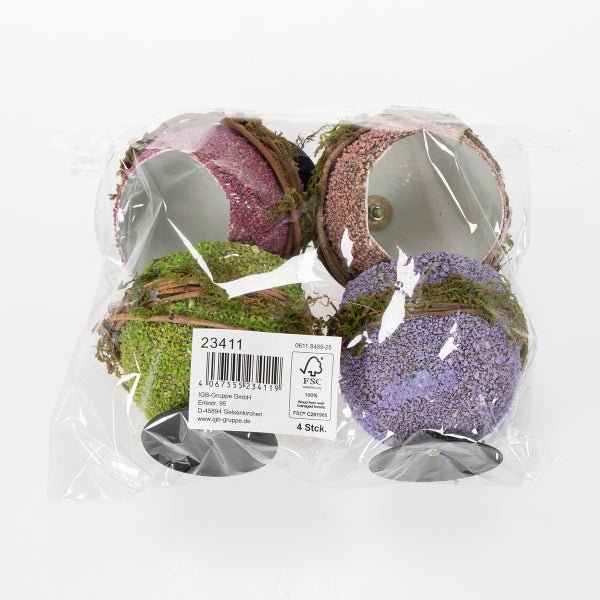 Vier Dekokugeln in Verpackung mit Moos und Zweigen
