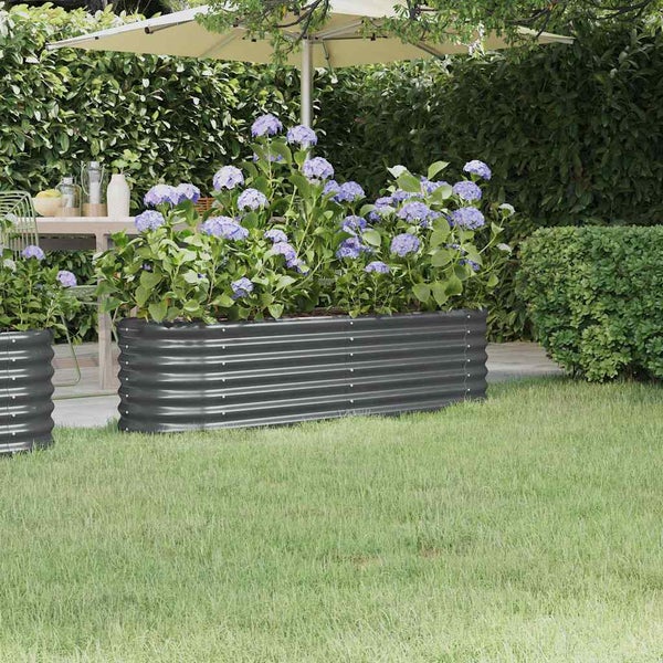 Rechteckiges Hochbeet aus gewelltem Metall zur Bepflanzung im Garten auf dem Rasen vor einer Hecke platziert.