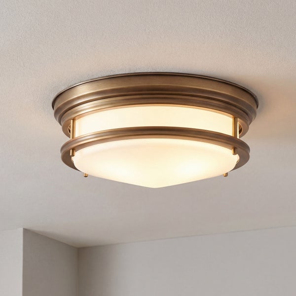 Runde Deckenleuchte mit mattiertem Glasdiffusor und dekorativem Metallring im Messing-Design, an der Decke montiert.