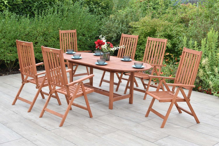 Gartenszene mit Holztisch und Stühlen auf einer Terrasse