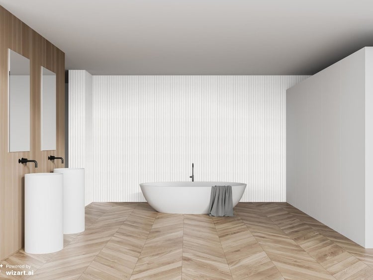 Modernes Badezimmer mit freistehender Badewanne, zwei Säulenwaschbecken und Parkettboden in Fischgrätoptik vor einer gerillten Wandverkleidung.
