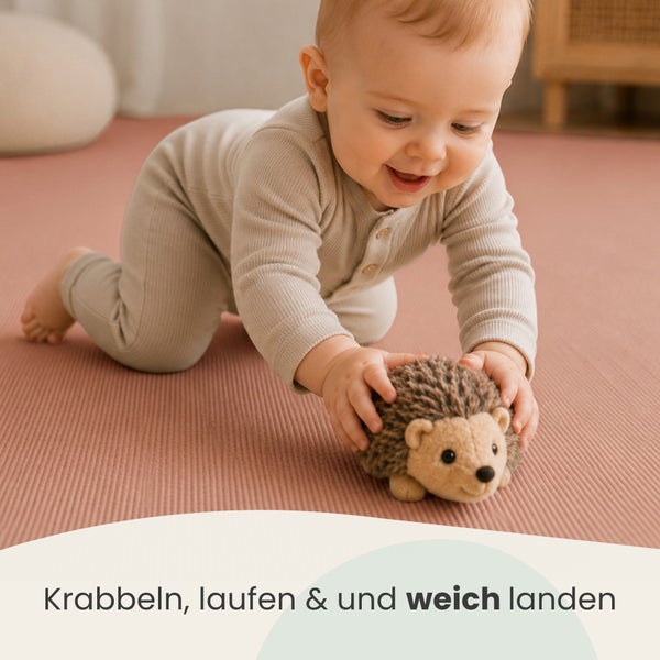 Kleinkind krabbelt auf einer weichen Spielmatte und spielt mit einem Stoffigel, ideal für sicheres Spielen im Kinderzimmer.