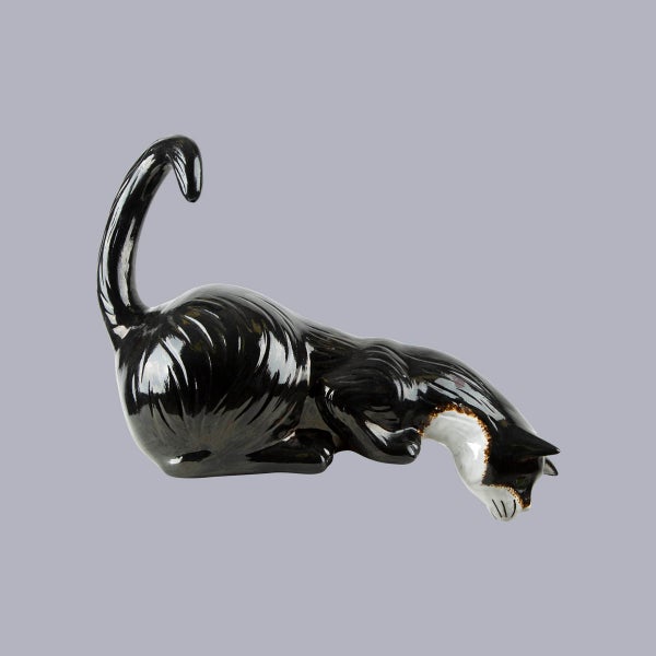 Dekofigur Katze aus Keramik, schwarz-weiß, lauernde Pose, glänzende Oberfläche.
