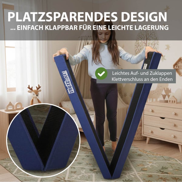 Ein Kind klappt einen blauen, faltbaren Schwebebalken in einem hellen Kinderzimmer zusammen. Der Turnbalken verfügt über einen Klettverschluss.