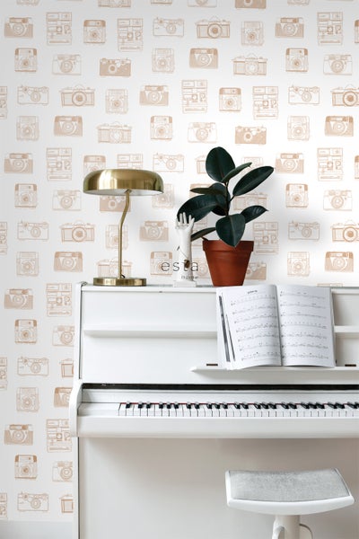 Szene mit Klavier, Tischleuchte und Tapete mit Kameramuster