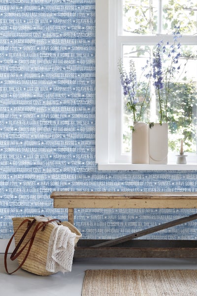 Dekorative Szene mit blau-weißer Tapete, Holztisch und Wohnaccessoires