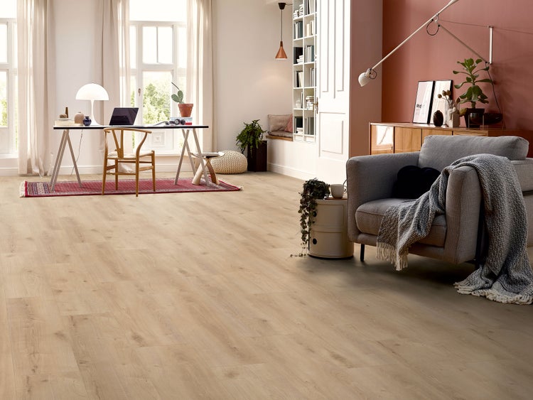 Helles Laminat in Holzoptik verlegt in einem geräumigen Wohnraum mit Arbeitsbereich und gemütlicher Sitzecke.