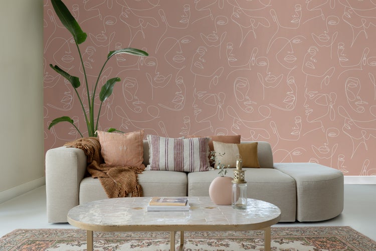 Wohnzimmer mit Sofa, Kissen und Wandtapete mit Gesichtsmuster