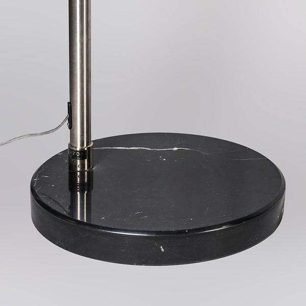 Detailaufnahme des runden Marmorfußes einer Stehlampe.