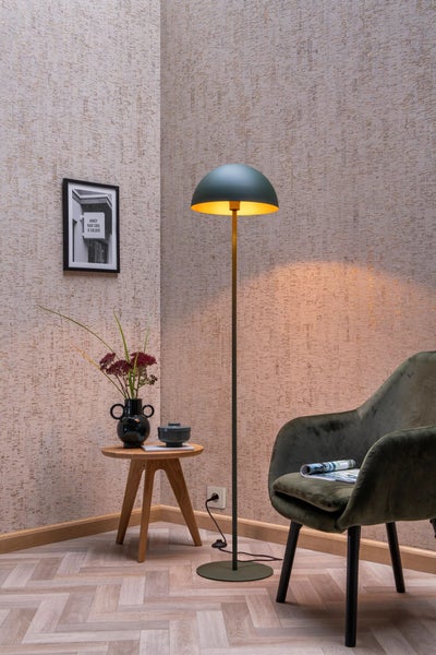 Dekoratives Interieur mit Stehlampe, Beistelltisch und Sessel in einem Zimmer