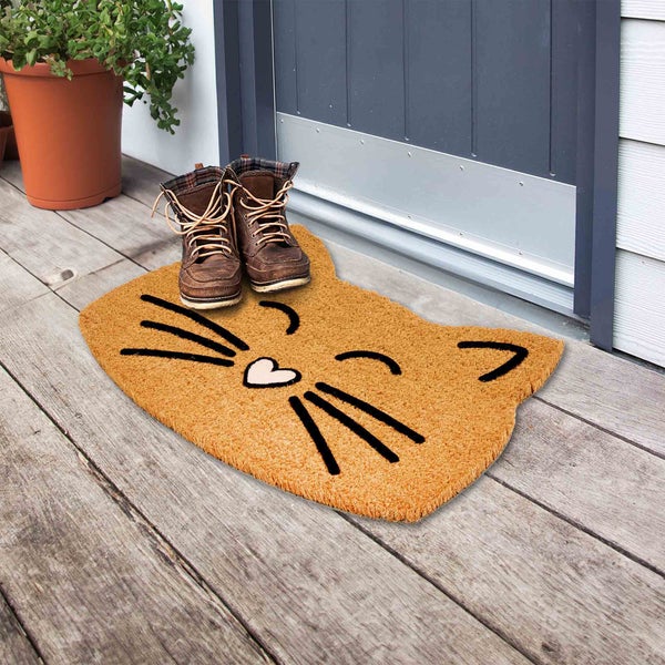 Fußmatte in Katzenform vor einer Haustür mit Schuhen