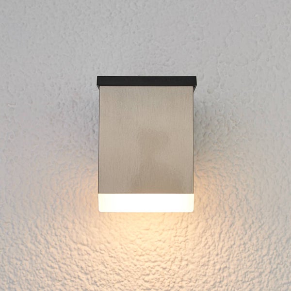 Moderne rechteckige Außenwandleuchte aus Metall mit Lichtaustritt nach unten an einer strukturierten Wand.