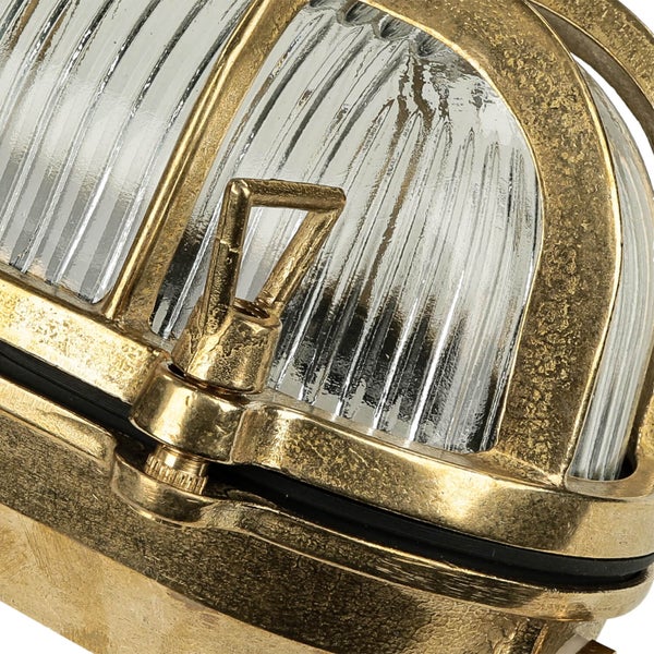 Nahaufnahme einer goldenen Schiffslampe mit geripptem Glas