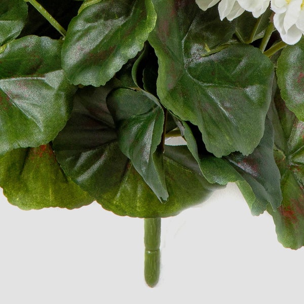 Detailansicht von künstlichen Geranienblättern mit weißen Blüten und grünem Stängel.