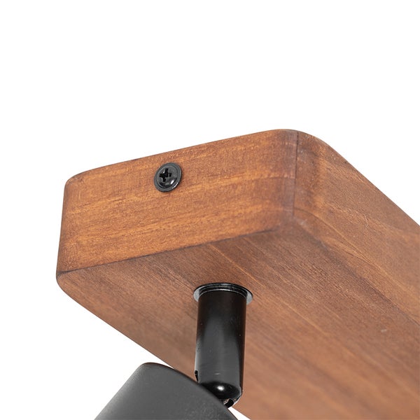 Detailaufnahme einer Deckenleuchte mit Holzplatte und schwarzem Befestigungselement