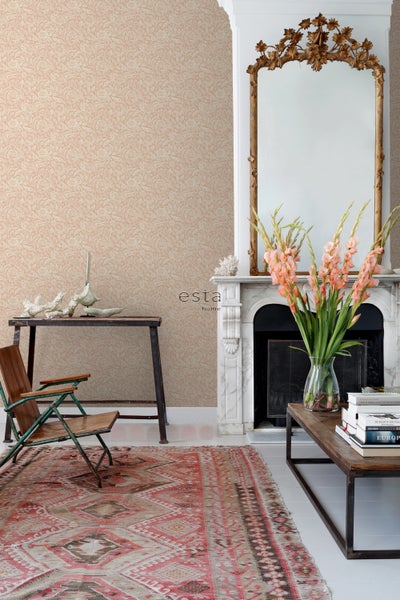 Wohnzimmer mit gemusterter Tapete, antikem Spiegel über einem Marmorkamin, einem Holztisch und einem gemusterten Teppich.