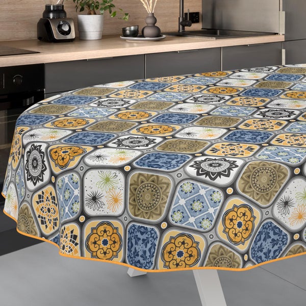 Runde Tischdecke mit Mosaikmuster aus Mandalas und floralen Motiven auf einem Tisch in einer modernen, hellen Küche.
