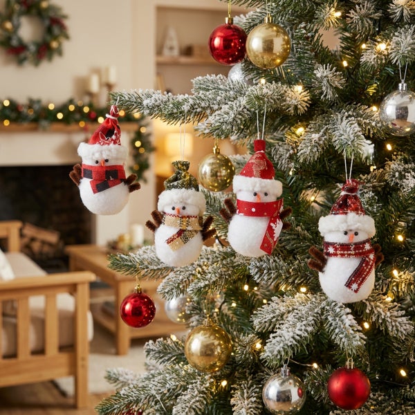 Weihnachtsbaum mit Schneemann Anhaengern und Christbaumkugeln im Wohnzimmer