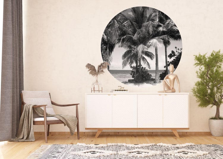 Wohnzimmer mit Sessel, Kommode und Wandtattoo mit Palmenmotiv in Schwarzweiß
