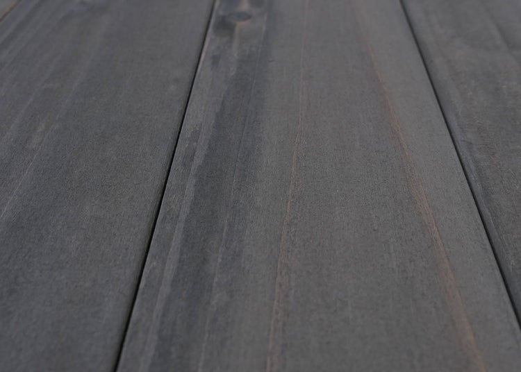 Dunkelgraue Terrassendielen aus Holz mit sichtbarer Maserung.