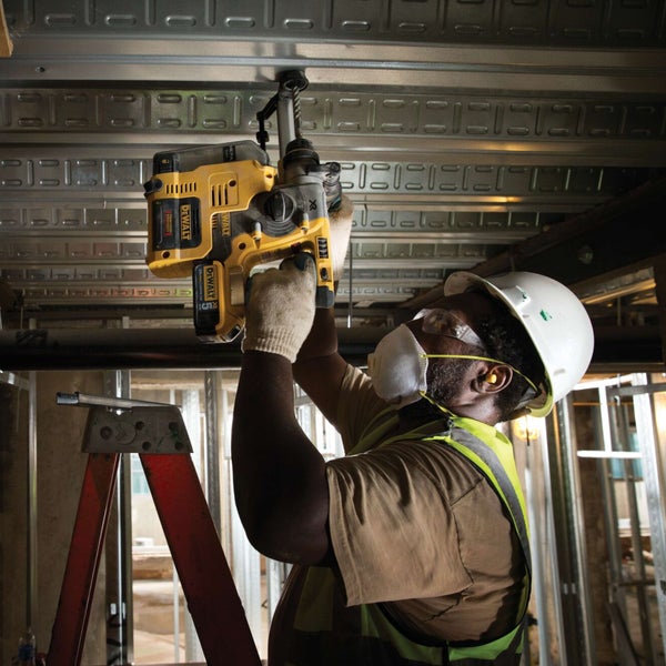 Ein Bauarbeiter verwendet einen Bohrhammer der Marke Dewalt zur Deckeninstallation.