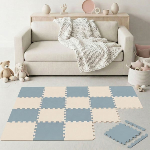 Quadratische Puzzle-Spielmatte aus Schaumstoff mit einzelnen Randstücken in einem hellen, organisierten Zimmer vor einem Sofa mit Kuscheltieren.