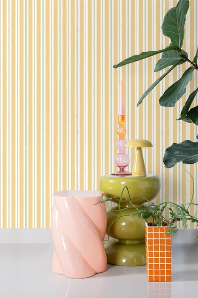 Dekorative Szene mit gestreifter Tapete, Hocker und Dekorationselementen