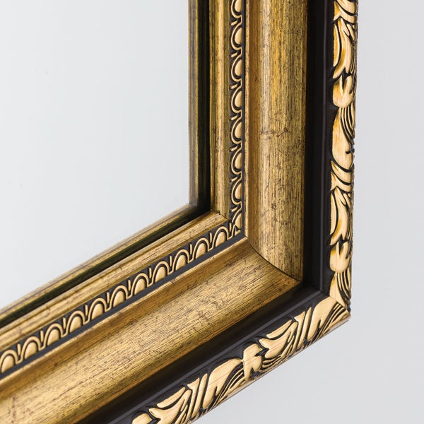 Wandspiegel mit einem verzierten Barockrahmen in antikem Design