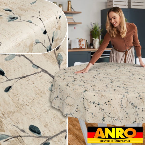 Runde beige Tischdecke mit botanischem Zweigmuster in einer hellen Küche, Detailansicht der Materialstruktur, ANRO Logo.