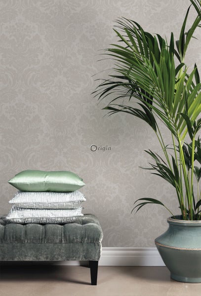 Dekorativer Wohnraum mit gemusterter Tapete, Hocker, Kissen und Zimmerpflanze.