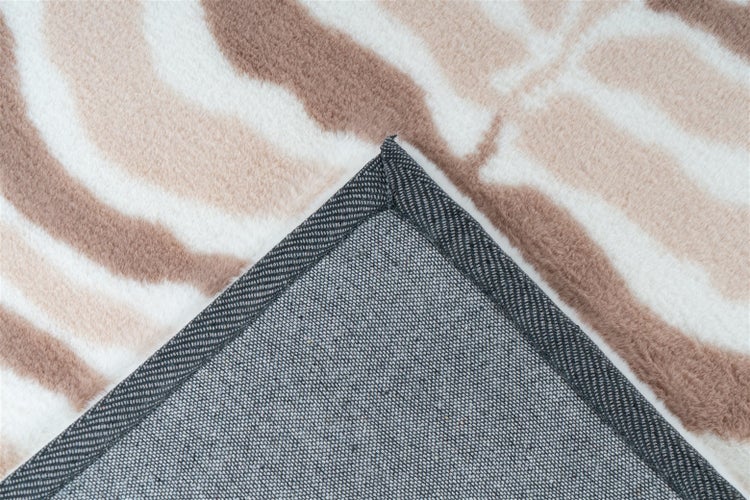 Teppich mit Zebramuster, Detailaufnahme der rutschfesten Unterseite und des verstärkten Rands.